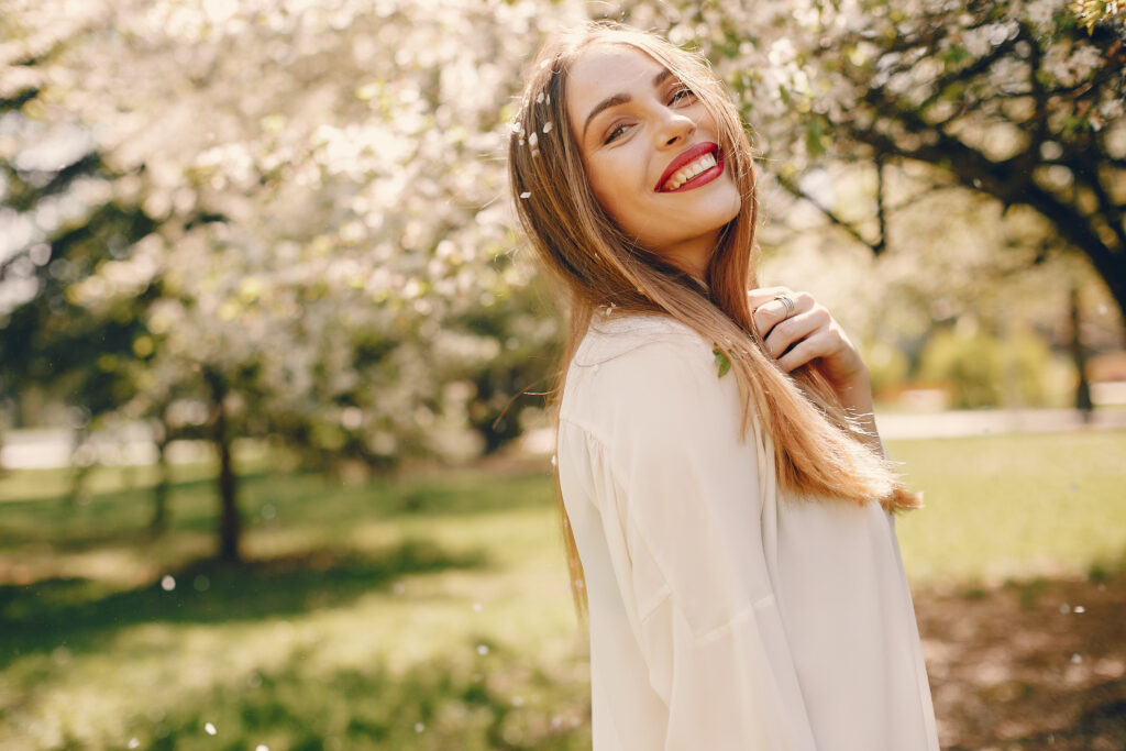 Beautiful girl in a white blouse. Woman in a summer park